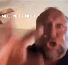 a man with a beard is making a funny face with the words neet neet neet in the background