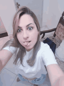 a woman is taking a selfie with her tongue out