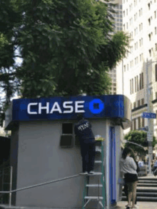 a man is on a ladder in front of a chase bank