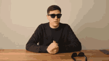 a man wearing sunglasses sitting at a table