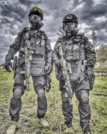 two soldiers wearing gas masks and holding guns pose for a picture