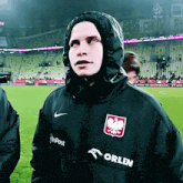 a person wearing a black jacket that says orlen