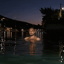 a man swimming in a body of water at night