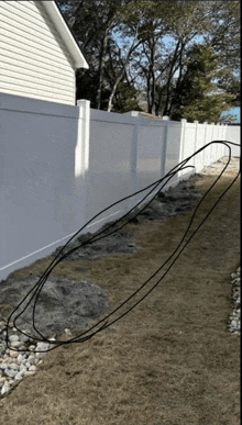 a white fence with a bunch of wires on the ground