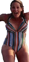 a woman wearing a striped swimsuit is jumping in the air