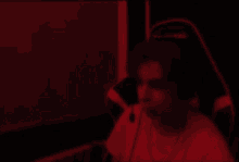 a man wearing headphones is dancing in a dark room in a red light .