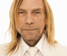 a man with long blonde hair and a white shirt and tie