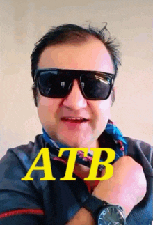 a man wearing sunglasses and a watch with the word atb written on it