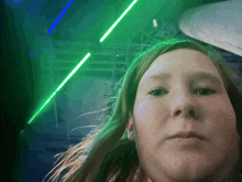 a woman is taking a selfie with a green light behind her