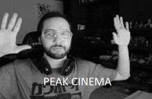 a black and white photo of a man wearing headphones and a peak cinema shirt