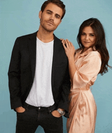 a man in a suit and a woman in a dress pose for a picture