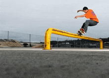 a skateboarder is doing a trick on a yellow rail