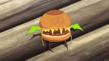 a cartoon drawing of a hamburger with wings and a face drawn on it