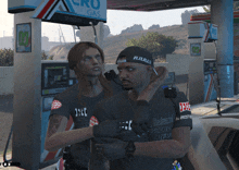 a man and a woman standing in front of a gas pump