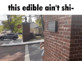 a sign on a brick wall says this edible ain t shi