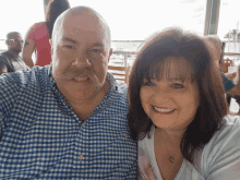 a man with a mustache is posing for a picture with his wife