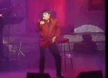 a man in a red suit singing into a microphone