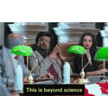 a group of people are sitting at a table with green lampshades and a sign that says `` this is beyond science '' .