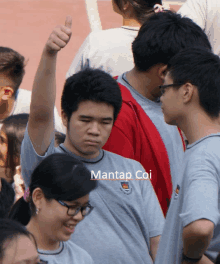 a man giving a thumbs up in a crowd of people with mantas coi written on the bottom