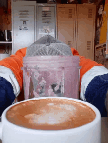 a cup of coffee sits on a table in front of a purple container that says ' safety first '