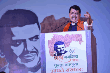 a man stands at a podium with a poster on it that says ' maharashtra '