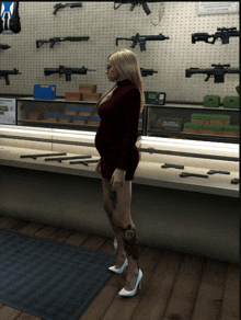 a woman in a red dress is standing in front of a display case with guns on it