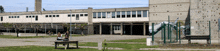 two women sit at a table in front of a building