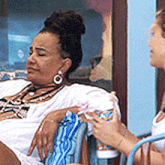 a woman in a white dress sits in a chair