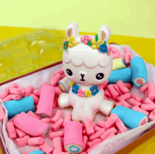 a toy llama is surrounded by pink and blue candy