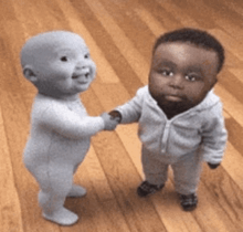 two babies are shaking hands on a wooden floor