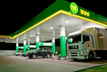 a man truck is parked in front of a gas station at night