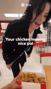 a woman in a black jacket stands next to a box of chicken nuggets with sora written on the bottom