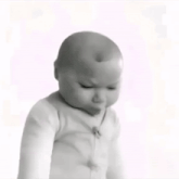 a black and white photo of a baby wearing a white sweater .