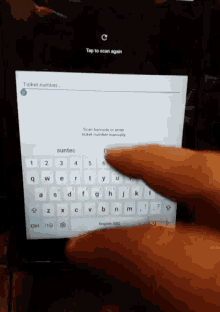 a person is typing a ticket number on a tablet