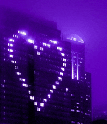 a building with a purple sky in the background is lit up with purple lights