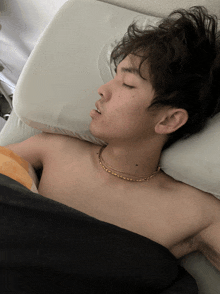 a shirtless man is sleeping on a pillow with his mouth open