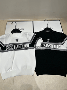a black and white christian dior sweater sits next to a white chanel box
