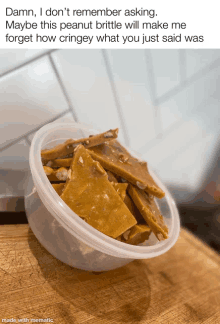 a plastic container filled with peanut brittle sits on a table