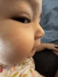 a close up of a baby 's face with a person 's hand on it