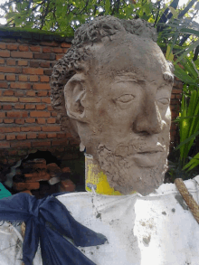 a statue of a man 's head is sitting on a white cloth