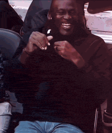 a man in a black shirt is smiling while holding an apple