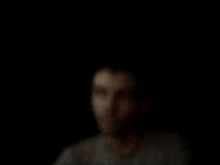 a blurred image of a man 's face in the dark