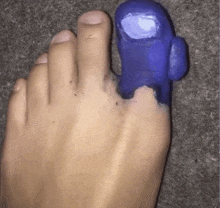 a close up of a person 's foot with a purple toy on it .