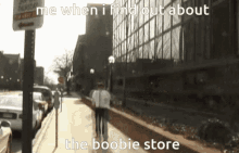 a couple walking down a sidewalk with the words me when i find out about the boobie store below them