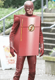 a man in a flash costume is wearing a refrigerator shaped costume