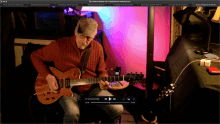 a man is playing a guitar in front of a screen that says common whisper feb 16 2020