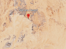 an aerial view of the sahara desert with a red pin pointing the location