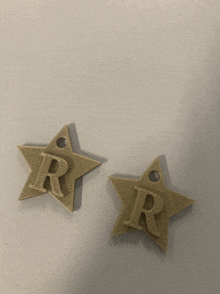 two stars with the letter r on them on a white surface