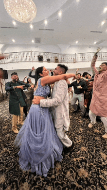 a man and a woman are dancing in a large room