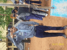 a man in a blue uniform salutes in front of a group of people in a photo taken on 12/15/2010